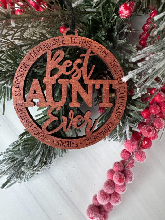 A wooden ornament with the words "LOVING", "TRUSTED", "CONFIDANT", "FUN", "SUPPORTIVE", "FRIENDLY", "GOOD LISTEN", and "SUPPORT" carved into it, surrounded by a wreath of pine branches and red berries.