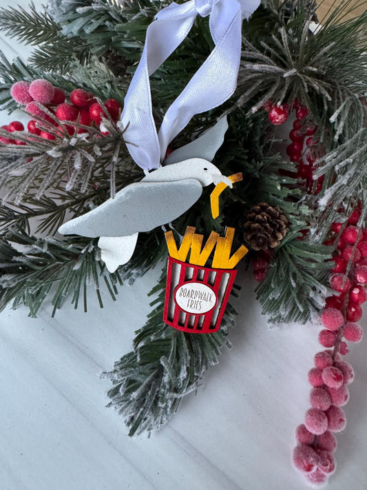 A close-up view of a Christmas wreath adorned with a white bird ornament, red berries, pine cones, and a red and white striped ornament.