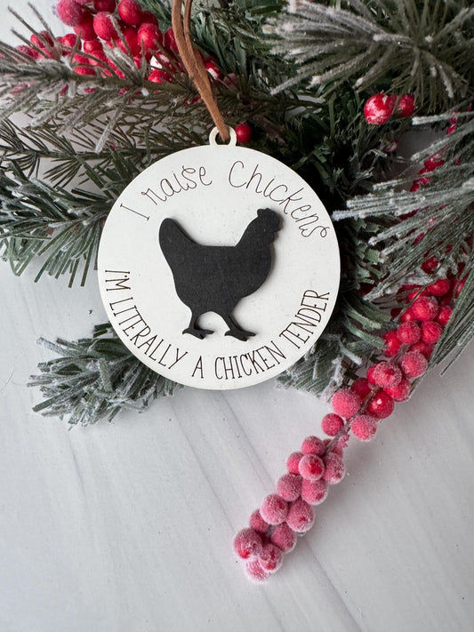 A white ornament with a silhouette of a chicken and the text "I love chickens" is displayed on a pine branch with red berries.