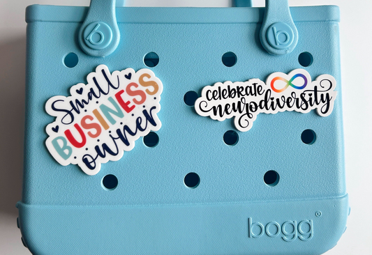 A light blue plastic tote bag with various stickers and text attached to it.