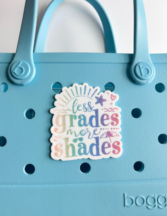 A sticker with the text "less grades more shades" is attached to a blue plastic bag.