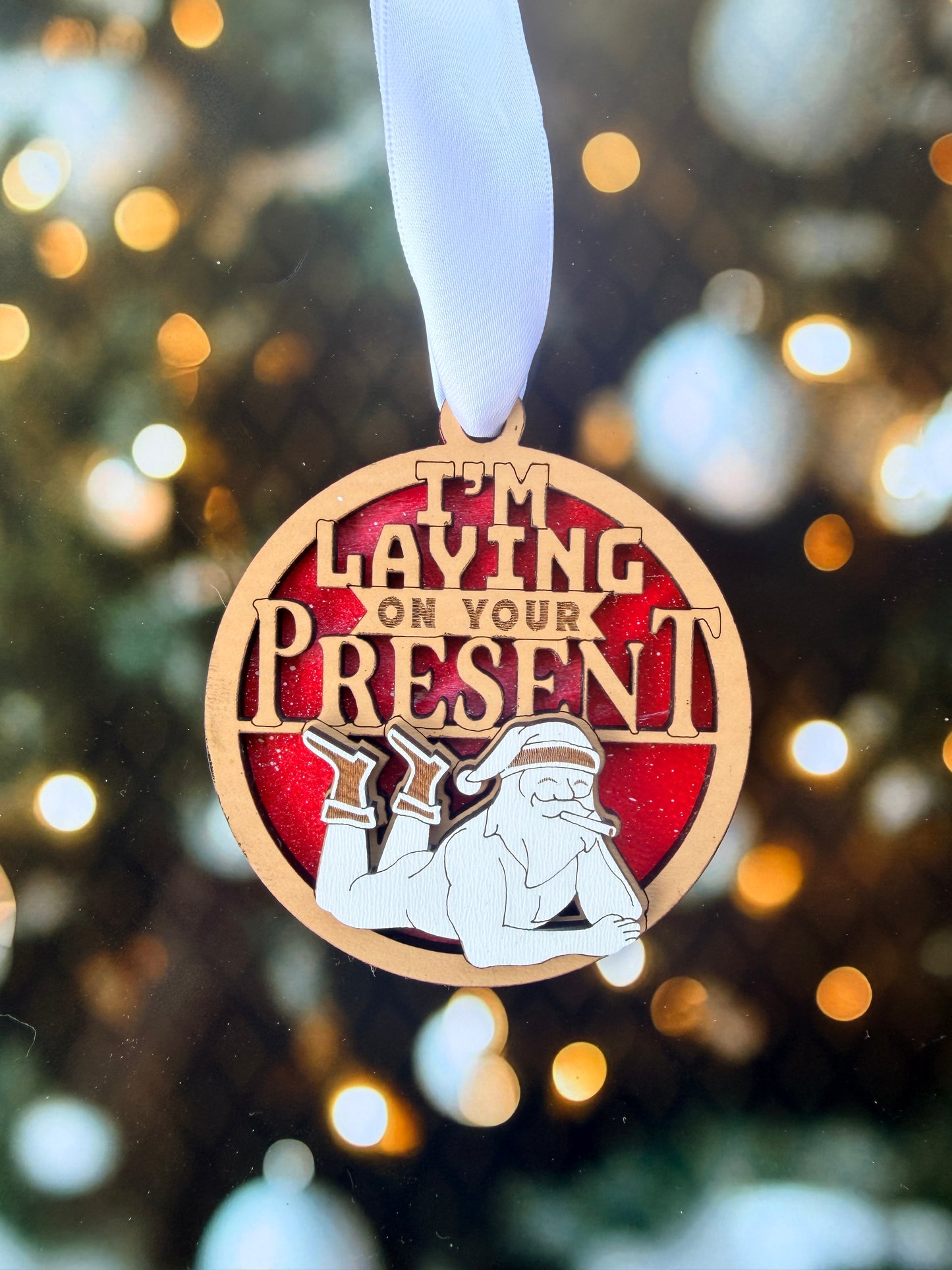 A wooden medal with a red background and a white ribbon, featuring a cartoon character and the text "Playing on Our Own"