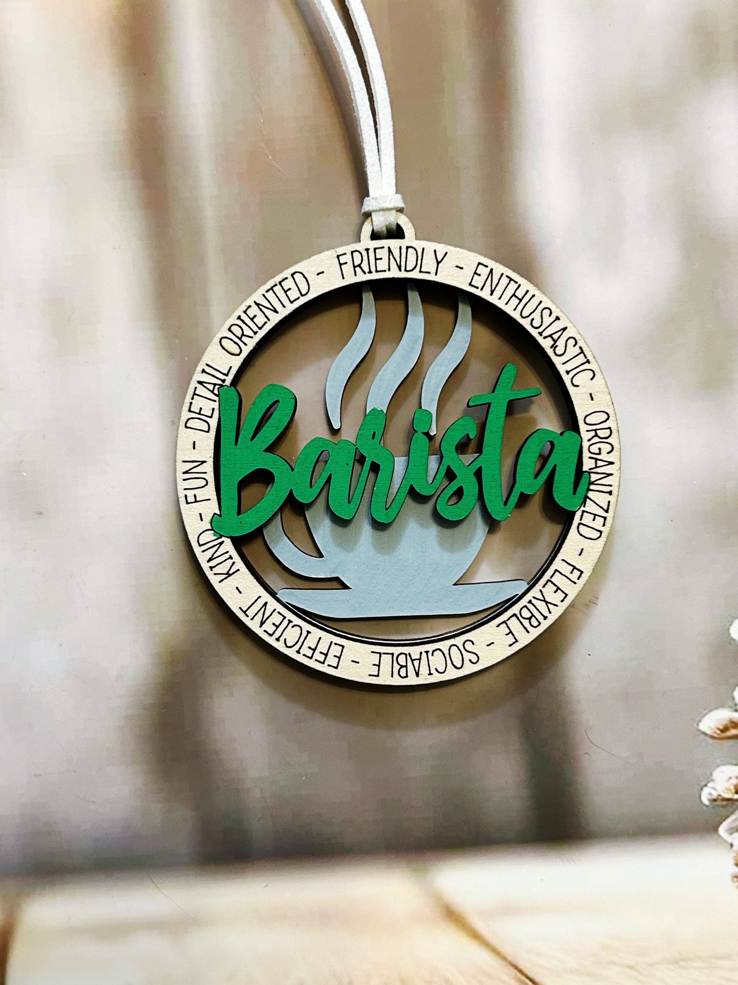 A pendant with the word "Barista" written on it, surrounded by the words "Friendly", "Enthusiastic", "Organized", "Efficient", "Social", and "Flexible".