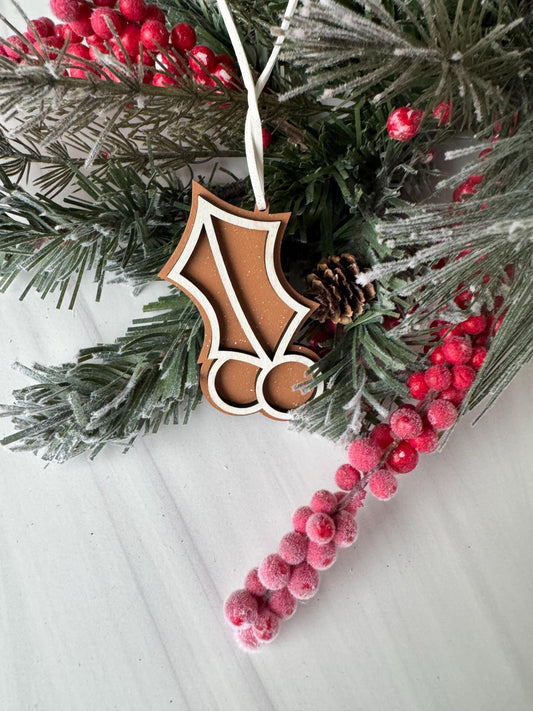 A close-up view of a Christmas wreath adorned with pine branches, red berries, and a wooden ornament.