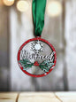 A red and green ornament with the word "Divorced" written on it, hanging from a green ribbon.