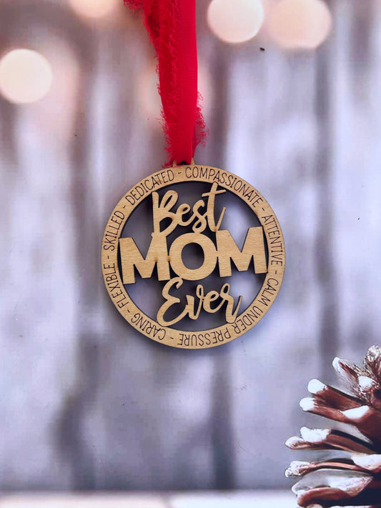 A wooden ornament with the text "Best Mom Ever" hanging from a string.