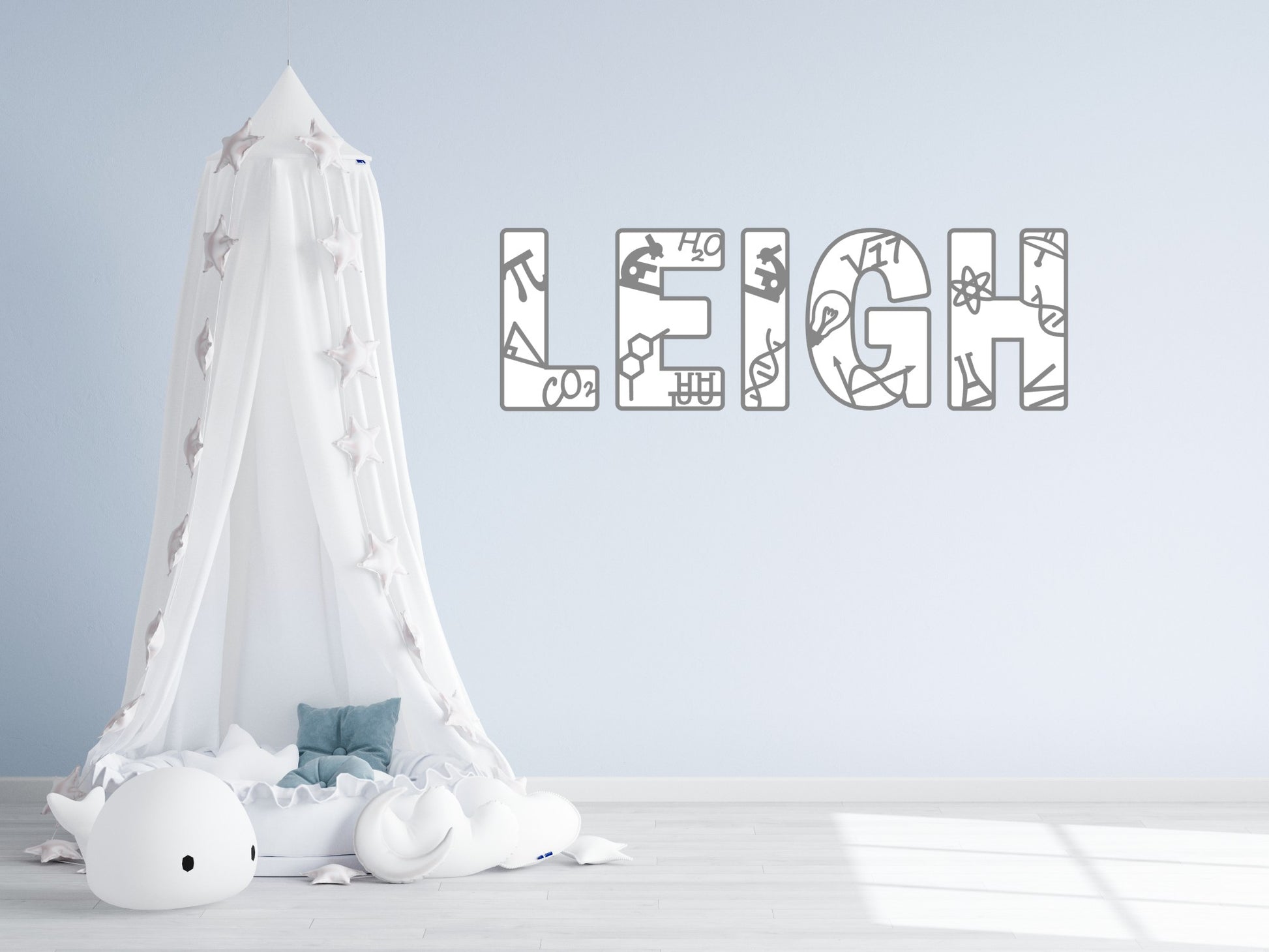 A white canopy bed with a canopy and a stuffed animal is placed in a room with a light blue wall. Above the bed, there is a large text decoration that spells out the name "LEIGH".