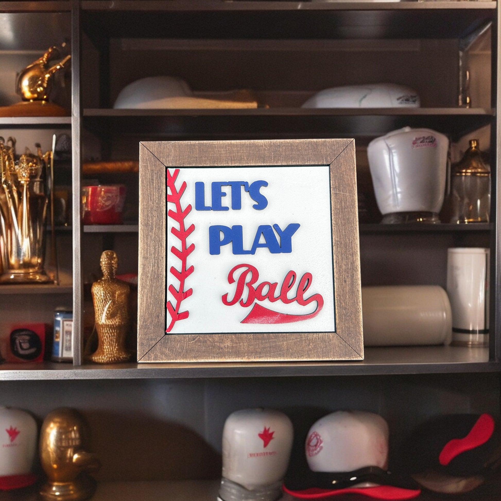 a sign that says lets play ball on a shelf