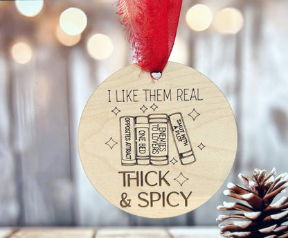 A wooden ornament with a red ribbon, featuring a humorous text and illustrations related to books.