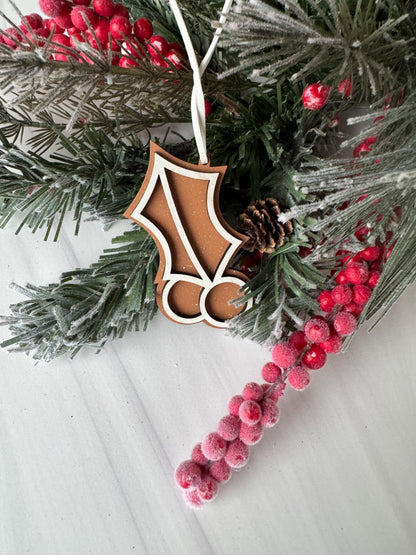 A close-up view of a Christmas wreath adorned with pine branches, red berries, and a wooden ornament.