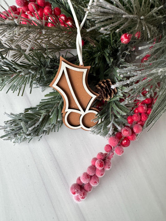 A close-up view of a Christmas wreath adorned with pine branches, red berries, and a wooden ornament.