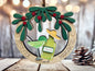 A wooden ornament with a festive design, featuring a green mistletoe, a tequila bottle, and a margarita glass, surrounded by the words "Mistletoe" and " margaritas".