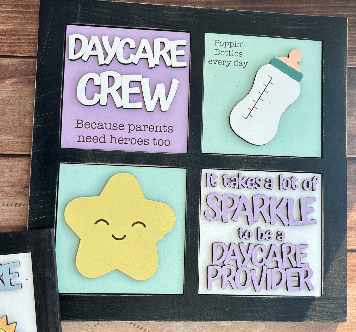 Decorative wall art with colorful text and shapes on a wooden background