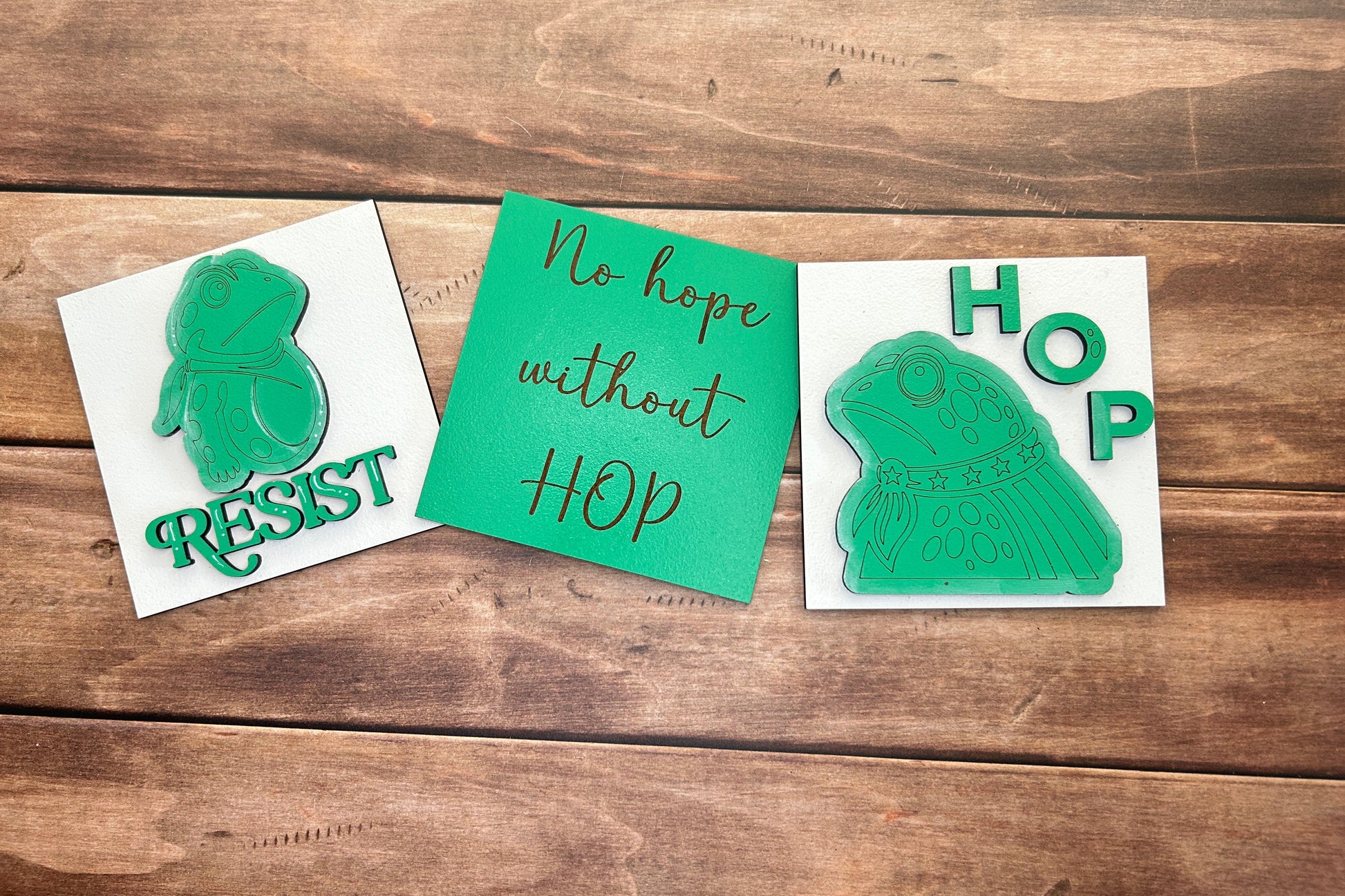Three green stamps on white paper with text on a wooden surface