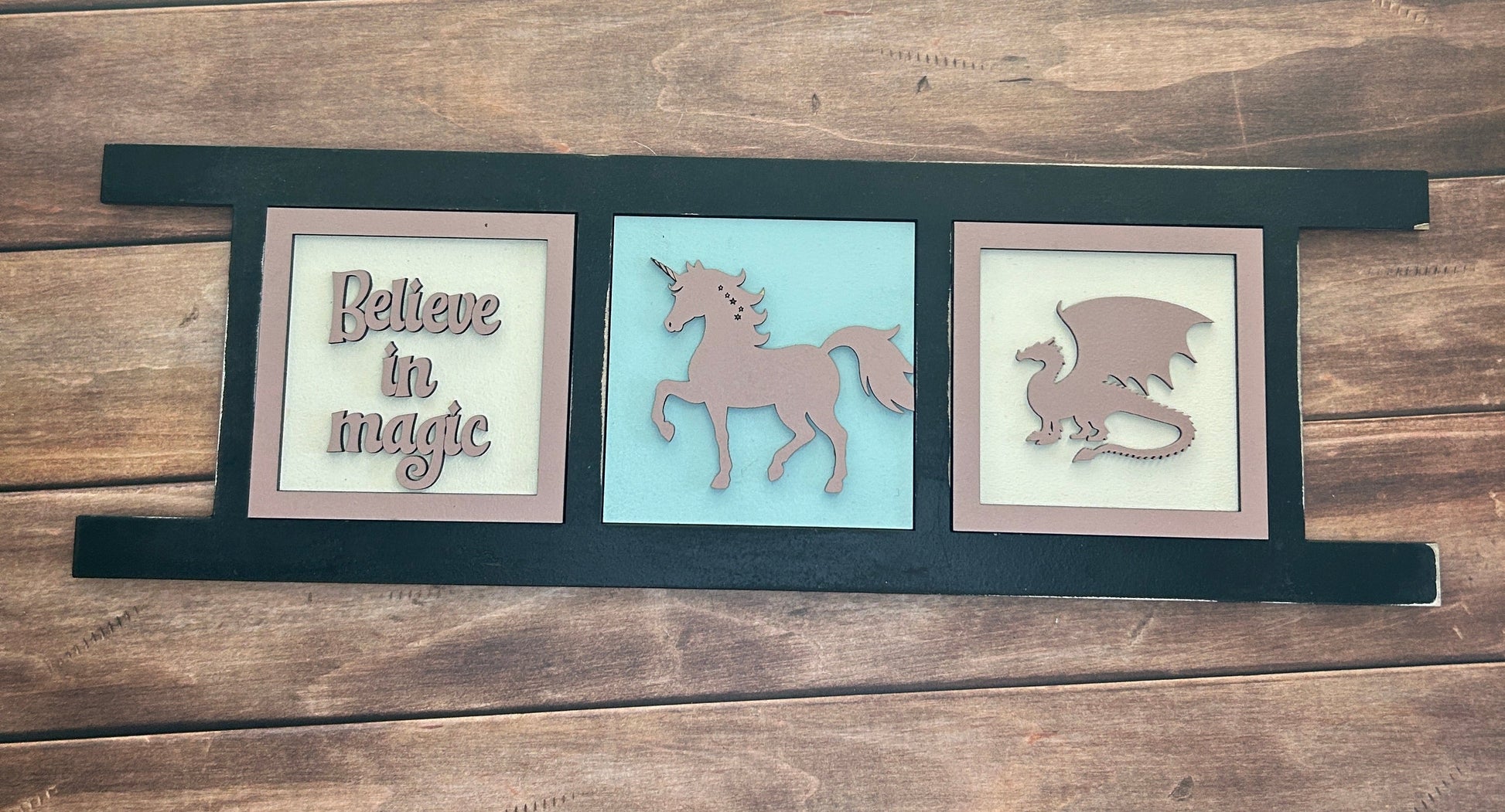 Decorative wall art with framed illustrations and text on a wooden panel.