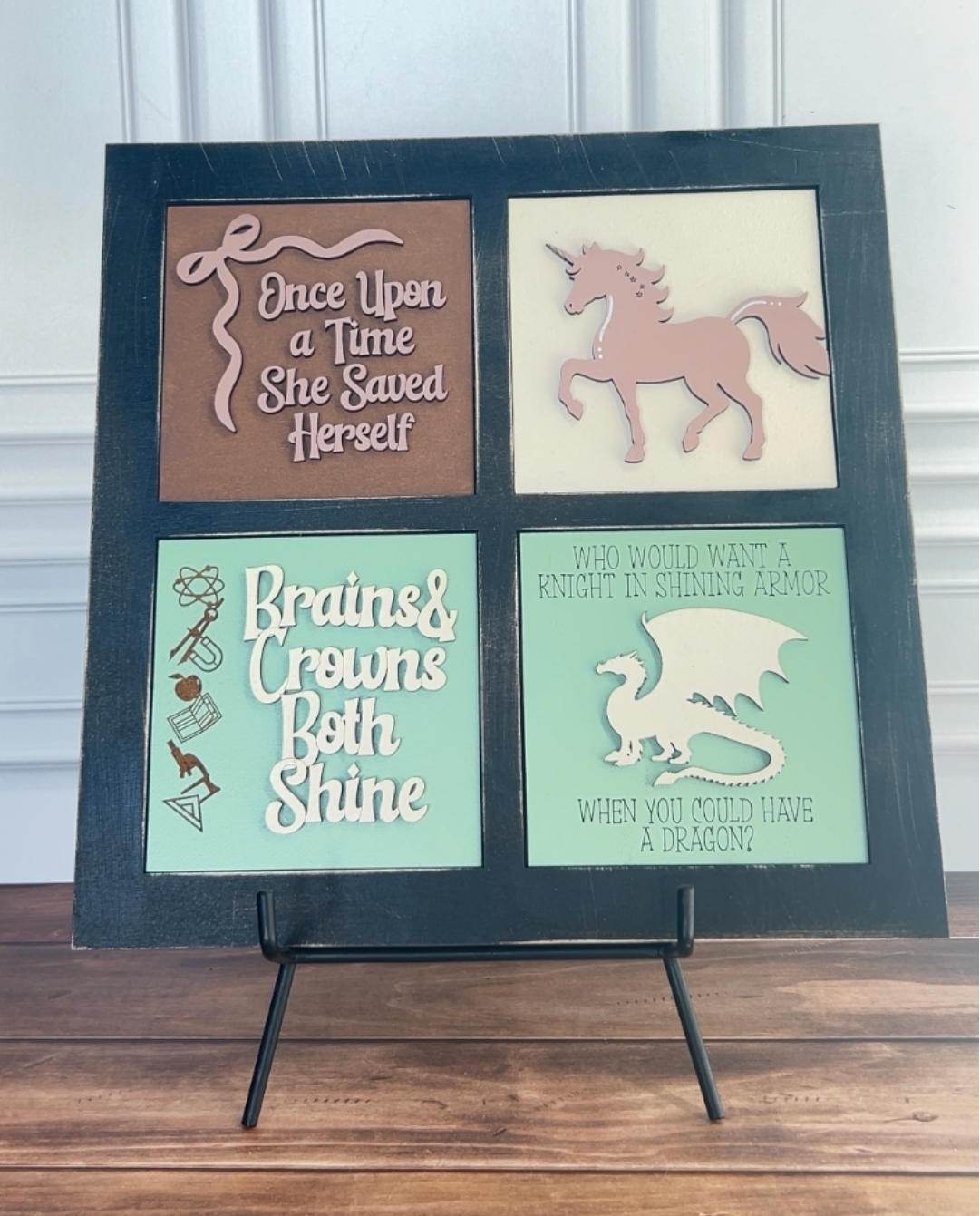 Decorative wall art with motivational phrases and illustrations on a stand.