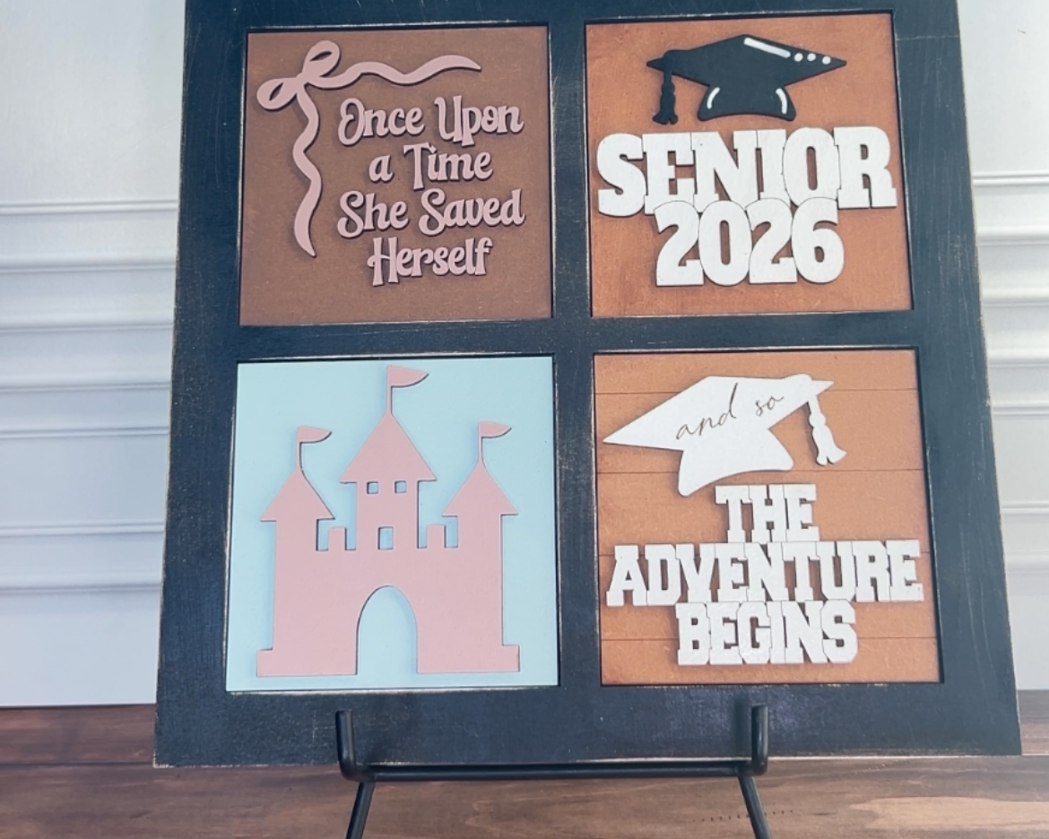 Decorative sign with cut-out phrases on a stand against a white wall.