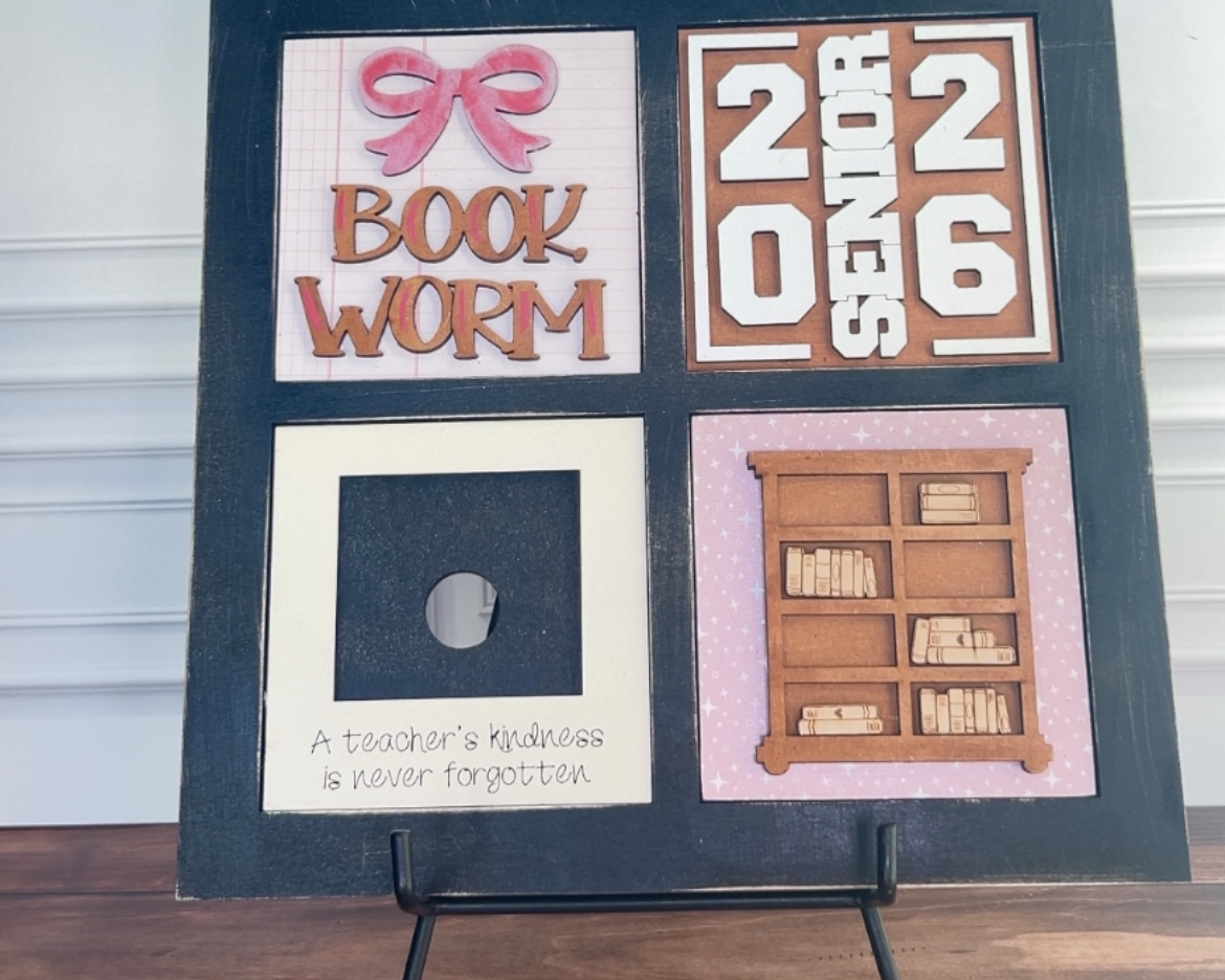 Decorative board with text and images on a stand against a white wall.