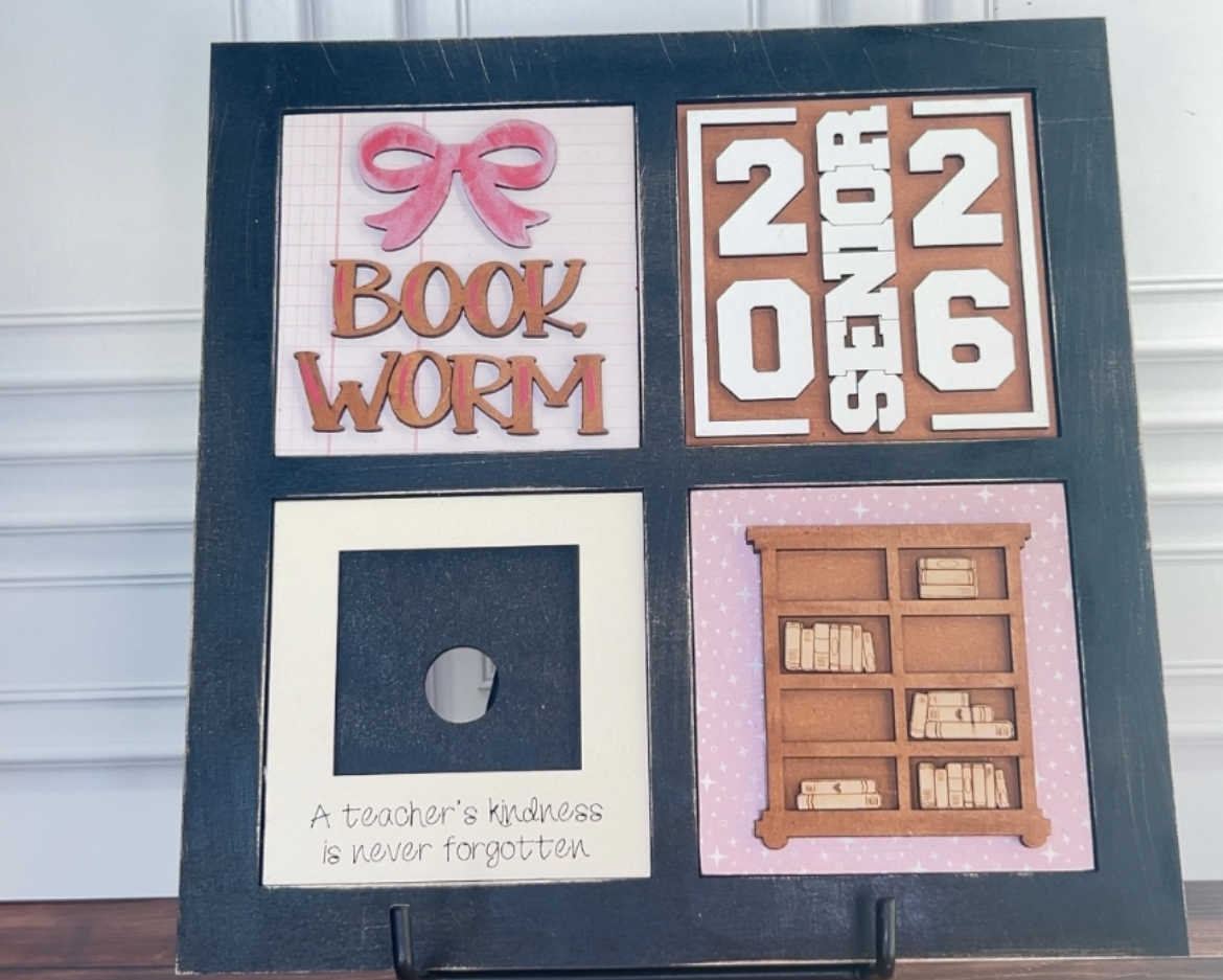 Decorative board with text and images on a stand against a white wall.