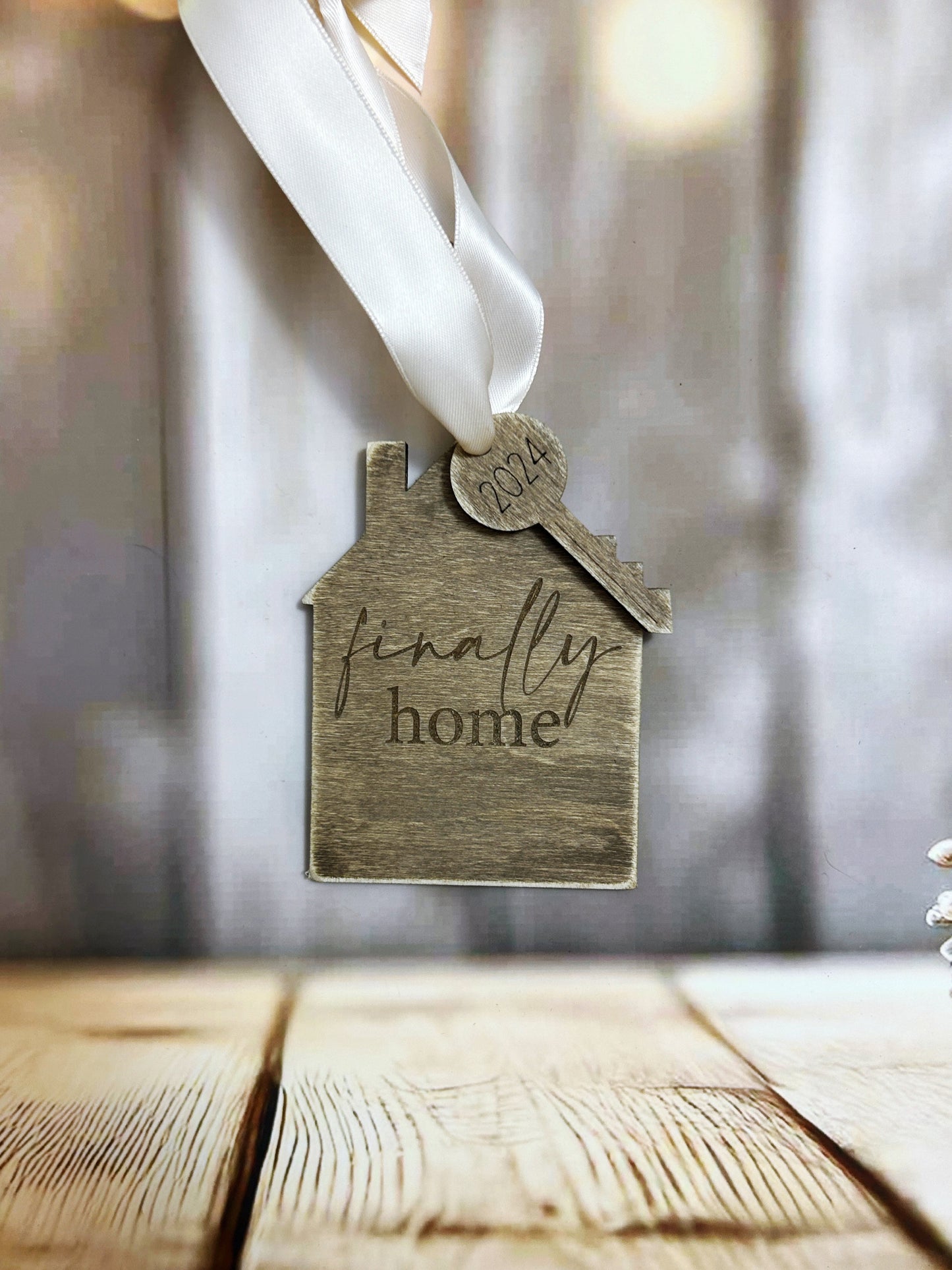 a wooden house ornament with a ribbon hanging from it