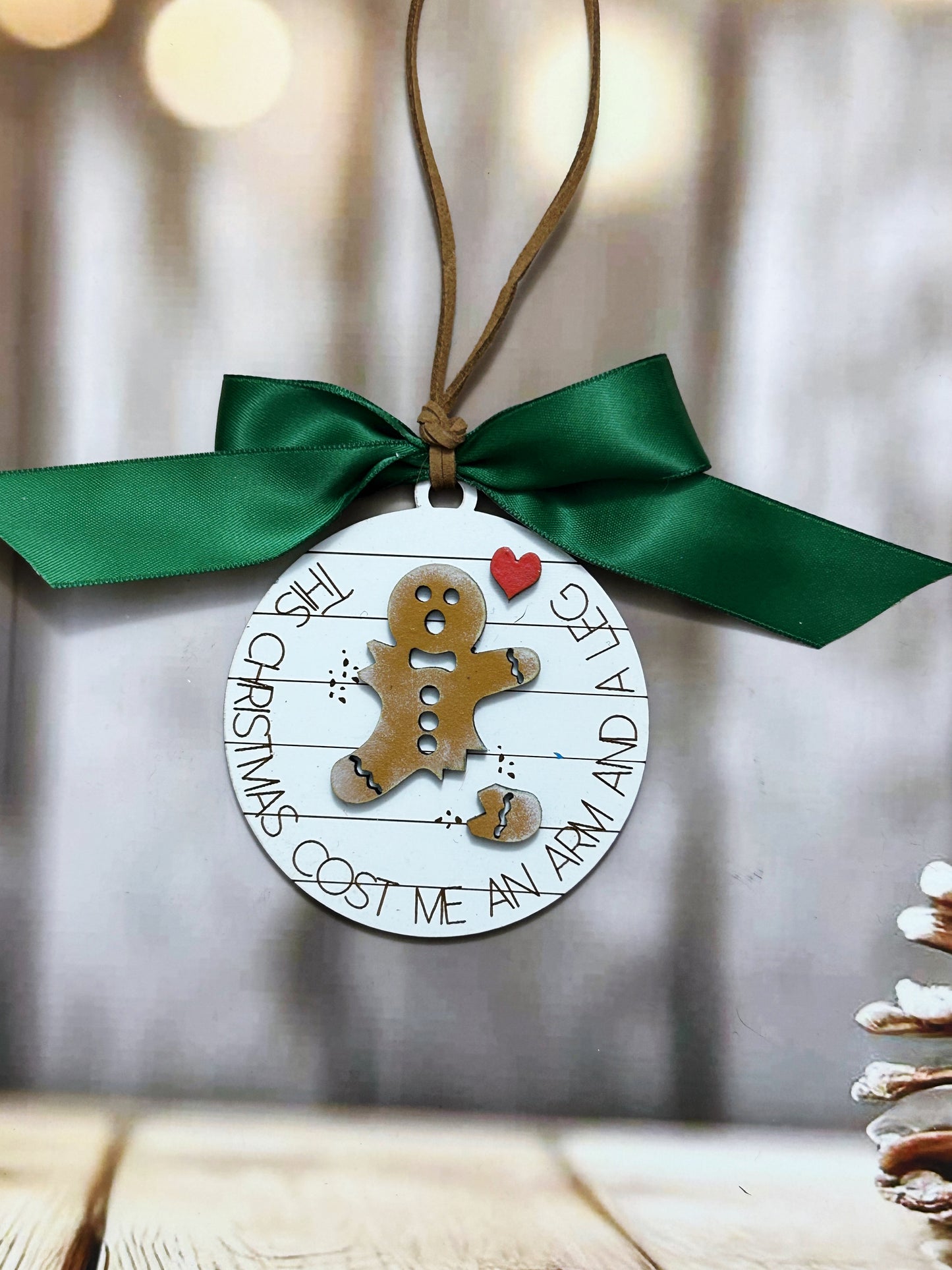 a wooden ornament with a green ribbon hanging from it