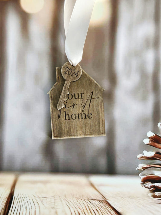 a house ornament hanging from a pine cone