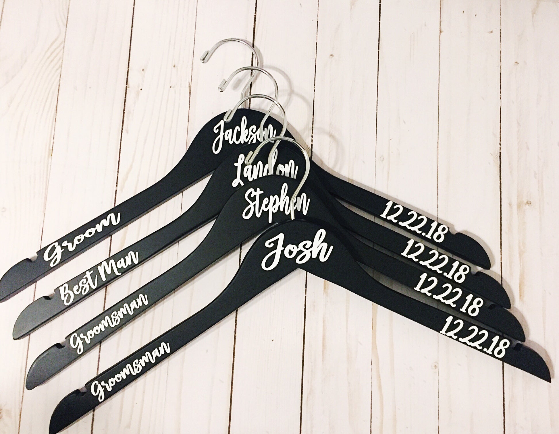 a set of five personalized wooden hangers