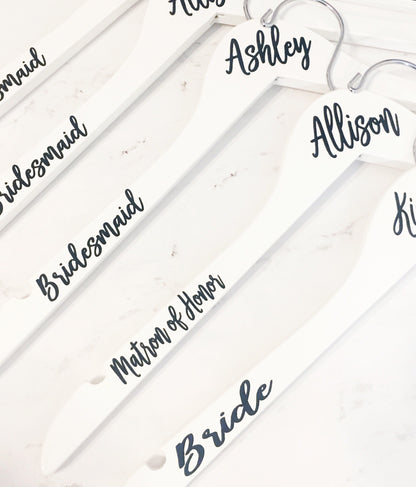 a bunch of white hangers with names on them