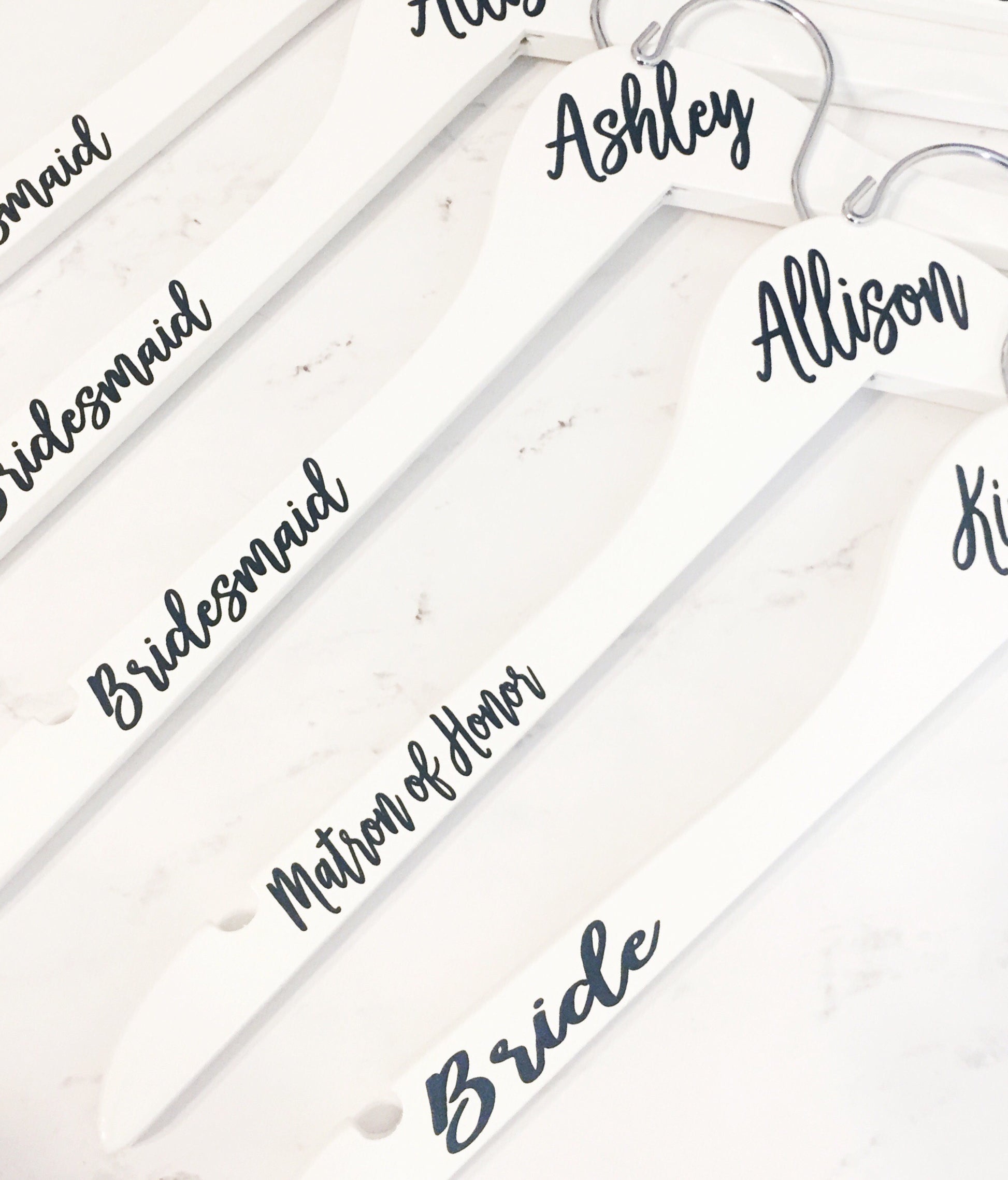 a bunch of white hangers with names on them