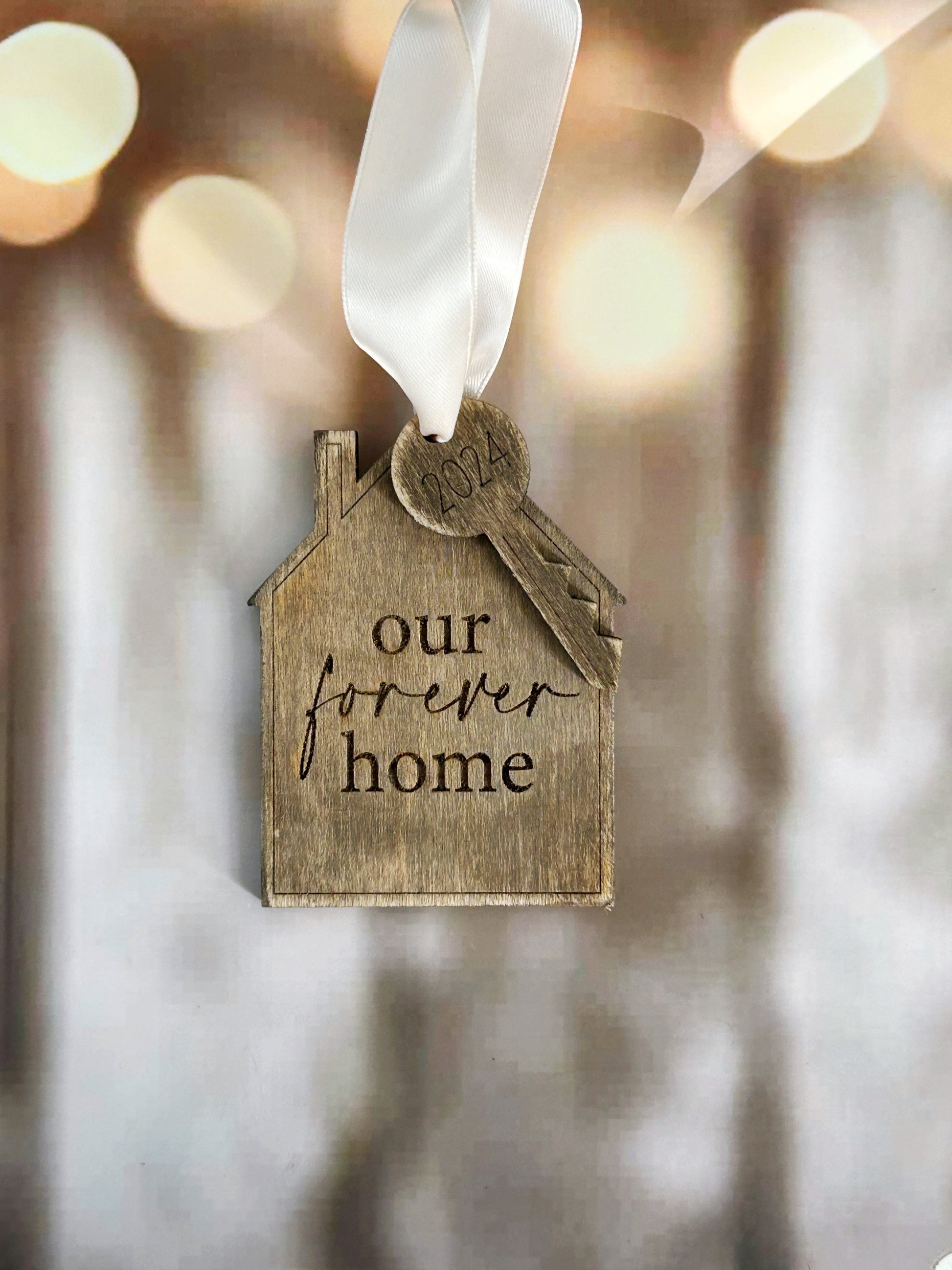 a house shaped ornament hanging from a string