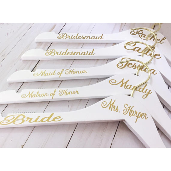 a bunch of white and gold wedding spoons