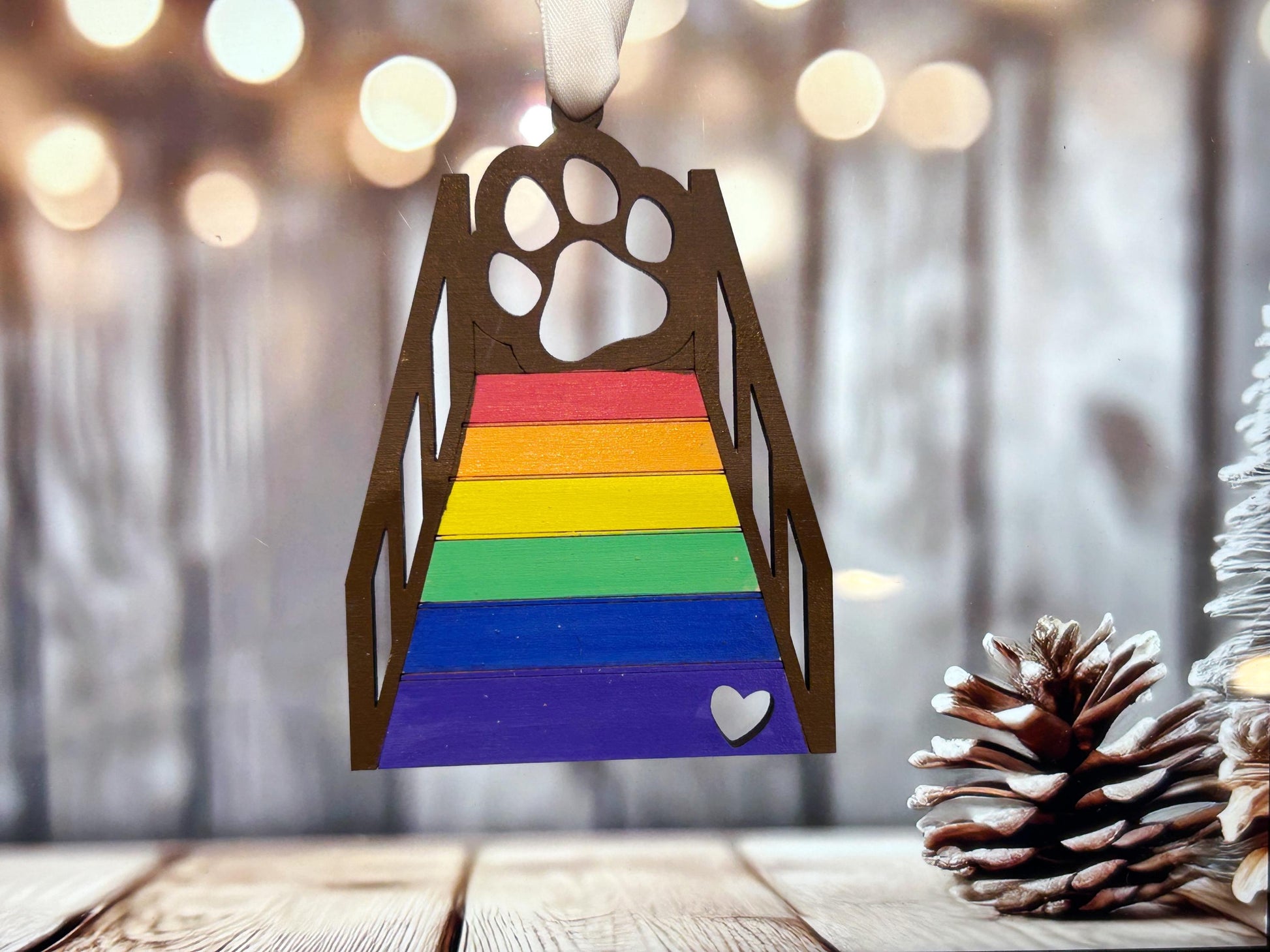 a wooden ornament with a dog's paw on top of a rainbow