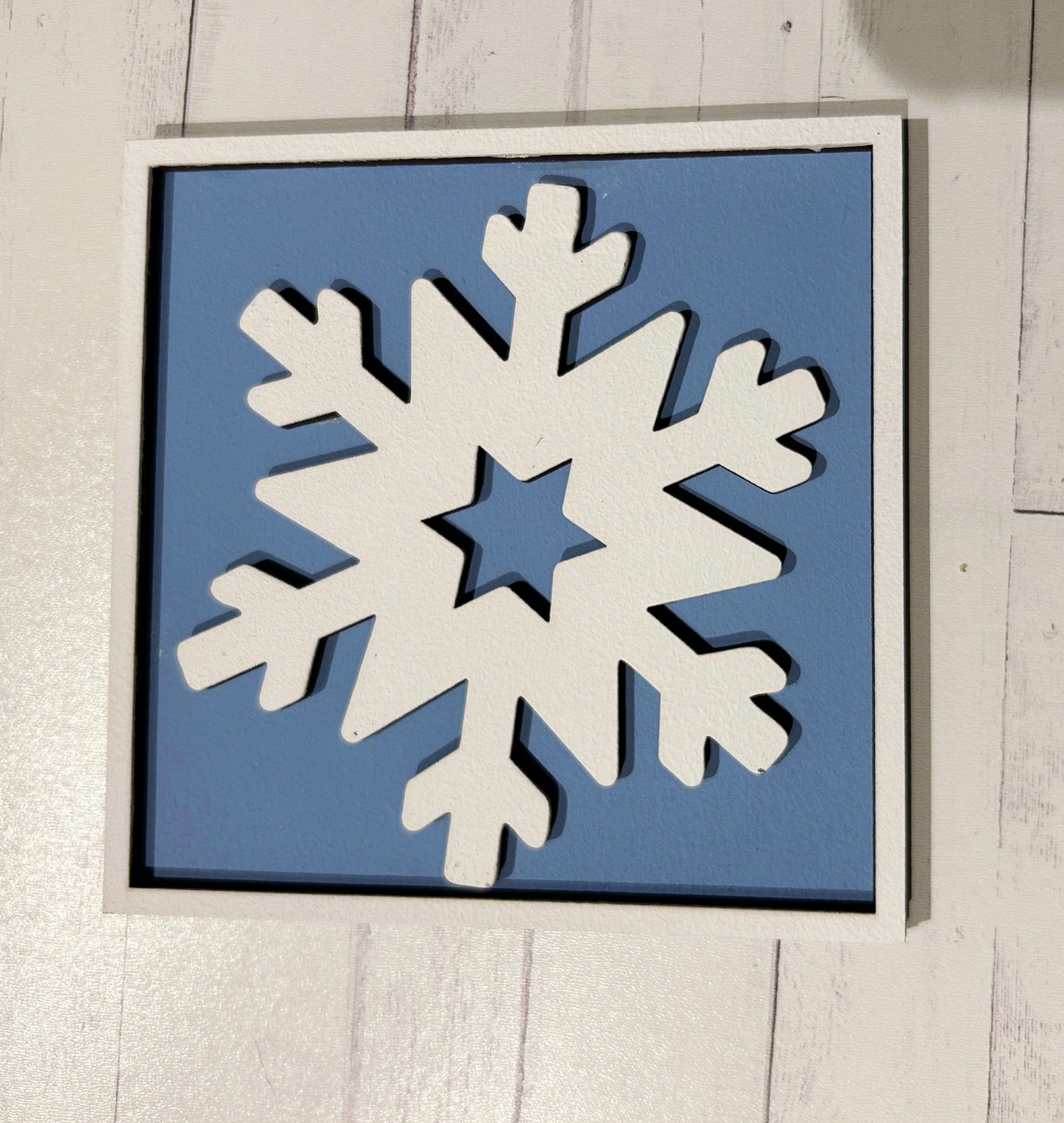 a picture of a snowflake hanging on a wall